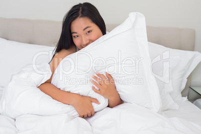 Smiling woman hugging her pillow
