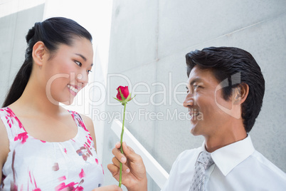 Man offering a red rose to girlfriend