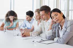 Casual businesswoman falling asleep during meeting