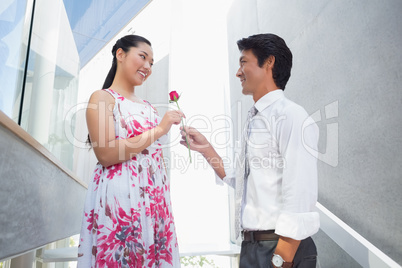 Man offering a red rose to girlfriend