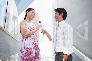 Man offering a red rose to girlfriend