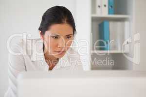 Casual businesswoman concentrating at her desk