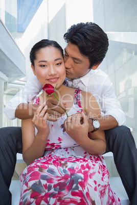Man offering a red rose to girlfriend