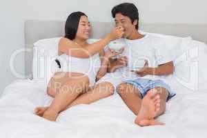 Happy couple having breakfast in bed