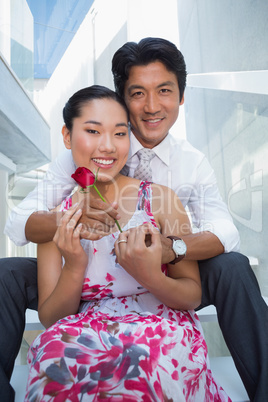 Man offering a red rose to girlfriend