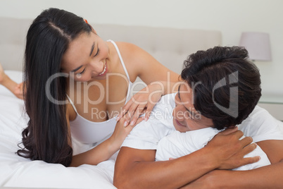 Happy couple lying on bed together