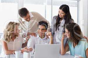 Casual smiling business team congratulating their colleague