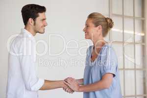 Casual business woman shaking hands with man