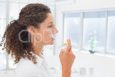 Casual businesswoman smoking an electronic cigarette