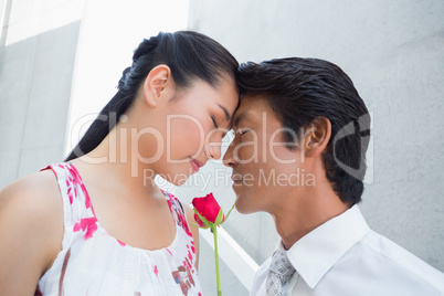 Man offering a red rose to girlfriend