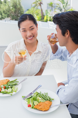 Happy couple having a meal together with white wine