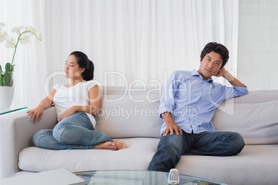 Couple not talking after a dispute on the sofa