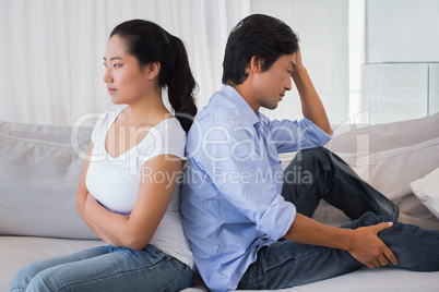 Couple not talking after a dispute on the sofa