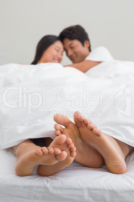 Couples feet sticking out from under duvet