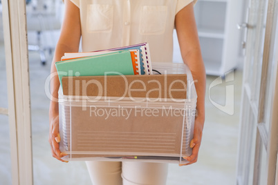 Fired businesswoman holding box of her things