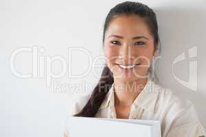 Casual businesswoman smiling at camera holding folder