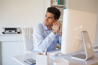 Casual businessman thinking at his desk