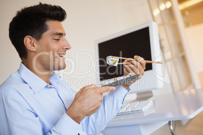 Casual businessman enjoying sushi at his desk