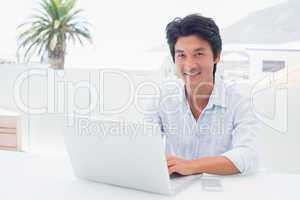 Smiling man using his laptop