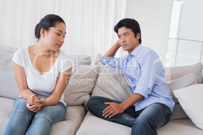 Couple not talking after a dispute on the sofa