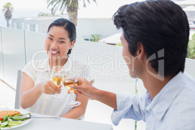 Happy couple having a meal together with white wine
