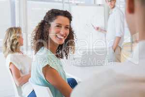 Casual businesswoman smiling at colleague during meeting