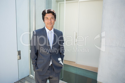 Confident estate agent standing at front door