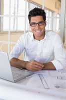 Casual architect working with laptop at desk