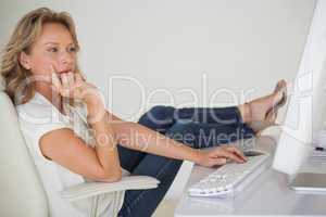 Casual businesswoman working with her feet up at desk