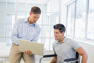 Casual businessman in wheelchair talking with colleague