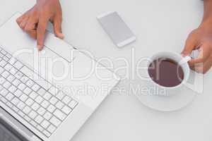 Man having coffee and using laptop