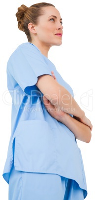 Pretty surgeon in blue scrubs with arms crossed