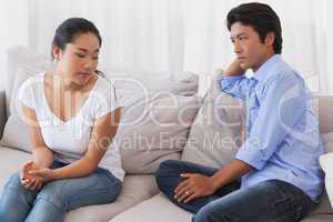 Couple not talking after a dispute on the sofa