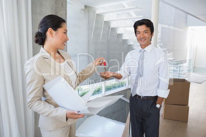 Estate agent giving house key to buyer