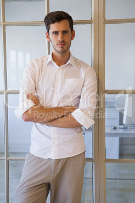 Casual businessman standing with arms crossed