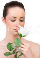 Beautiful brunette smelling white rose
