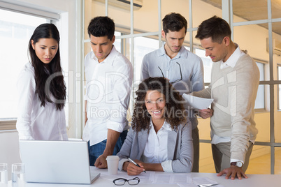 Casual business team having a meeting with woman smiling at came