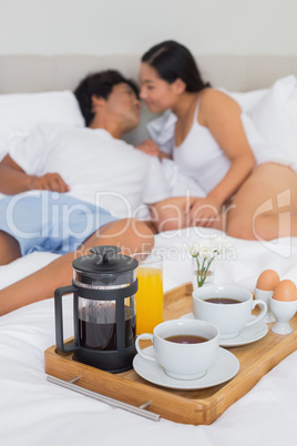 Affectionate couple having breakfast in bed