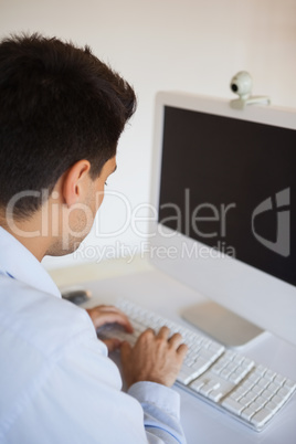 Casual businessman typing at his desk