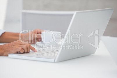 Man using laptop while having a coffee