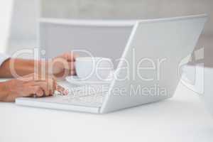 Man using laptop while having a coffee