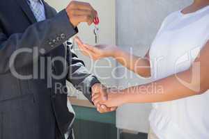 Estate agent giving house key to buyer