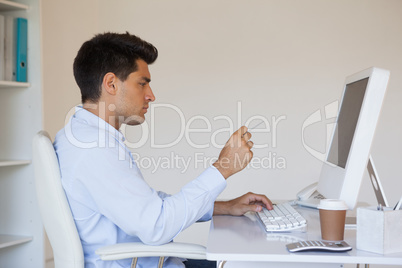 Casual businessman concentrating at his desk