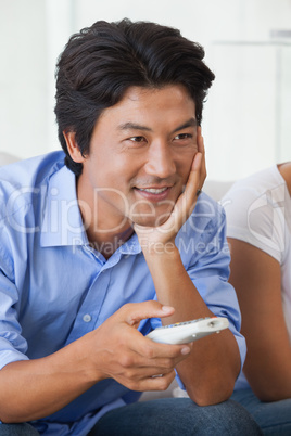 Happy man sitting on couch watching tv Happy man sitting on couch watching tv