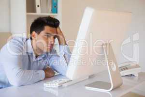 Casual businessman slumped at his desk