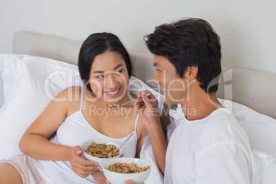 Happy couple having breakfast in bed