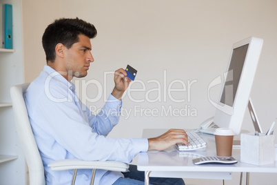 Casual businessman shopping online at his desk