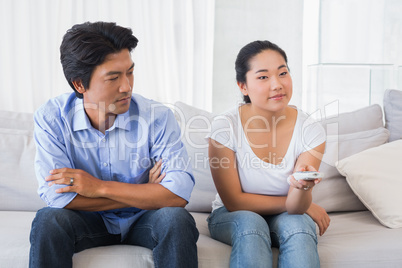 Man looking at girlfriend changing channel