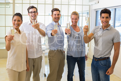 Casual business team toasting with champagne to camera