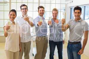 Casual business team toasting with champagne to camera